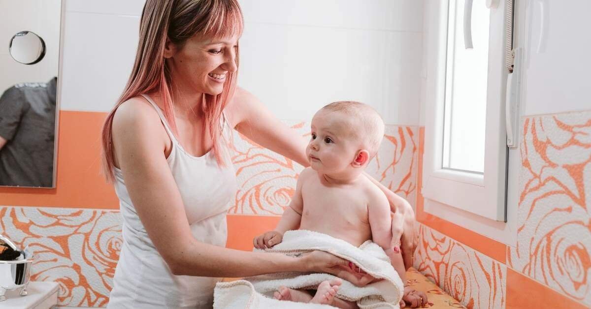 Mother holding baby learning how to treat baby heat rash